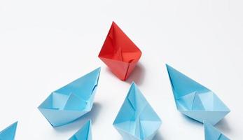 group of paper boats on a white background. concept of a strong leader in a team, manipulation of the masses, following new perspectives, collaboration and unification. Startup photo