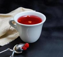 hot tea from a viburnum in a white ceramic mug photo