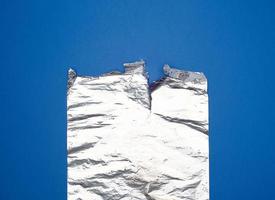 gray foil for baking and packaging food on a blue background photo