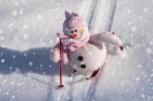 Textile snowman with snow slides down hill skiing photo