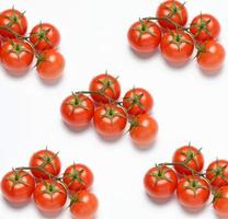 red ripe tomatoes on a green branch on white background, healthy vegetable photo