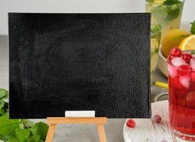 empty black chalk board for writing a summer drink recipe and a glass with berry lemonade photo