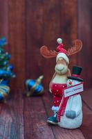 Christmas background with reindeer and a snowman on a brown wooden background photo