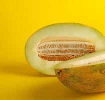 piece of ripe melon with seeds on a yellow background photo