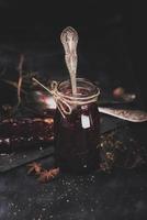 mermelada de frambuesa en un frasco de vidrio con una cuchara de hierro dentro foto