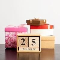 wooden calendar of cubes with the date of December 25 and a stack of boxes with gifts photo