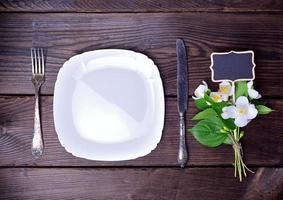 Empty white plate with cutlery photo