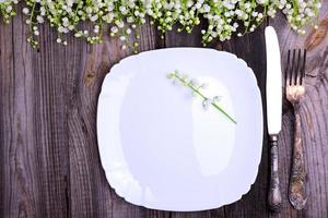 White plate with vintage iron cutlery on a gray wooden surface photo