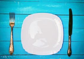 Empty square white plate with iron fork and knife photo