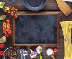 empty black frame and ingredients for cooking pasta photo