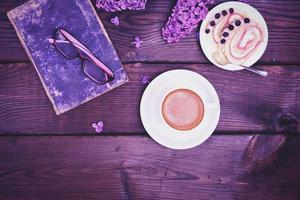 Coffee in a white cup with a saucer and a biscuit cake on a wooden table photo