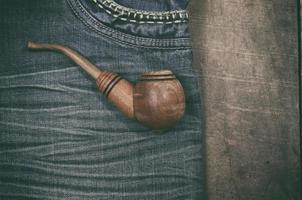 smoking wooden pipe on blue dzhinskah worn photo