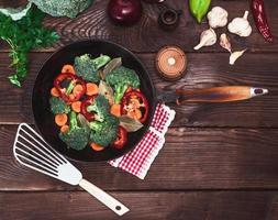 fresh vegetables in a black round frying pan photo