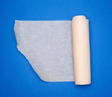 rollo de papel pergamino marrón sobre fondo azul, espacio de copia foto