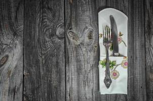 Table knife and fork on gray wooden surface photo