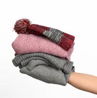 female hand holding a stack of clothes, help and volunteering concept. Sorting things photo