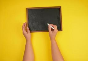 black chalk frame and two female hands with a piece of white chalk photo
