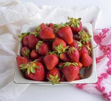 fresh ripe red strawberries in a white iron plate photo