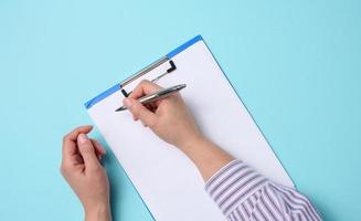 blank white sheets and two female hands, top view. Text writing, list photo