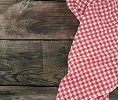 red-white textile kitchen towel on a wooden background from old gray boards photo