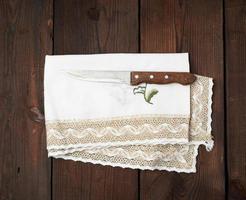 old knife and embroidered white dishcloth with lace photo