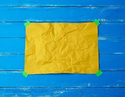 empty yellow crumpled sheet of paper glued with green sticky pieces of paper photo