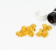 scattered oval tablets with fish oil, omega 3 on a white background photo