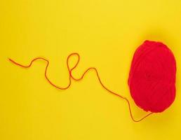 big skein of red wool on a yellow background photo