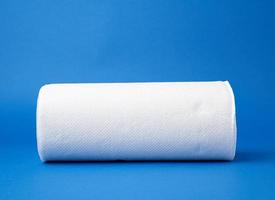 rollo retorcido de toalla de papel blanco sobre un fondo azul foto
