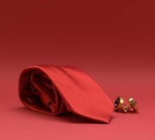 twisted silk red tie and cufflinks on a red background photo