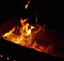 burning wooden logs in the fire at night photo