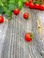 small red cherry tomatoes on wooden gray background, selective focus
