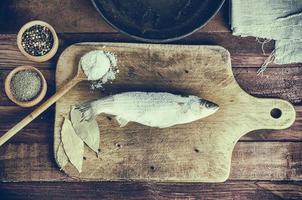 Frozen fish on the kitchen board photo