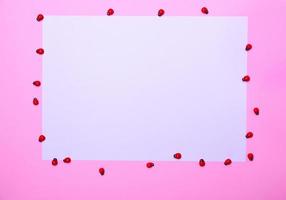 White sheet of paper on a pink surface, photo