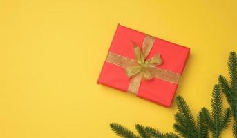 red gift box tied with ribbon on a gray background, top view. Festive backdrop photo