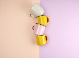 multi-colored ceramic cups with a handle on an abstract pastel background photo