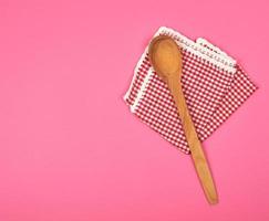 cuchara de madera sobre una toalla de cocina roja foto