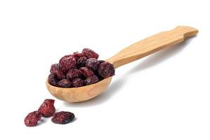 bunch of dried cranberries in a wooden spoon on a white background. Delicious berry photo