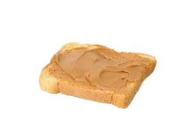 square slice of wheat bread smeared with peanut butter isolated on white background photo