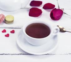 black tea in a white mug with a saucer photo