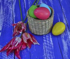 Easter chocolate eggs in a wicker basket on a wooden background photo