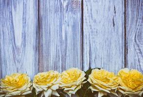 Bouquet of yellow roses on a white wooden background photo