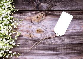 etiqueta de papel blanco vacía con una cuerda sobre un fondo de madera gris, foto