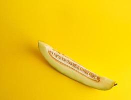 piece of ripe melon with seeds on a yellow background photo