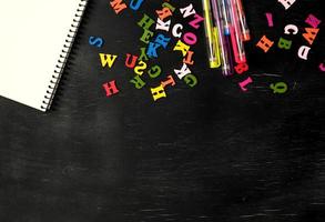 multicolored small wooden letters of the English alphabet on a black chalk board photo