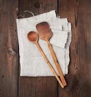 cuchara vieja de madera y espátula en una servilleta de lino gris foto