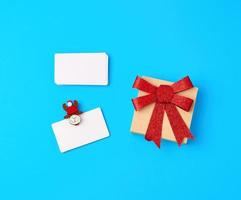 empty white paper business cards and holiday clothespins on a blue background photo