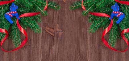 Christmas background with branches of fir and decorations on a brown wooden background photo