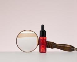 botella de vidrio rojo con pipeta para cosméticos, aceites y suero. publicidad y promoción de productos foto