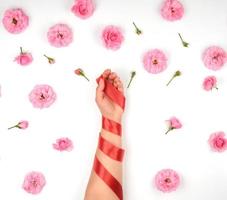 female hand with smooth skin wrapped with red silk ribbon photo